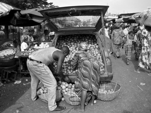 Une africaine achetant des fruits au marché de Cotonou.