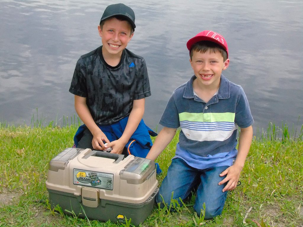Deux jeunes garçons et leur coffre à pêche